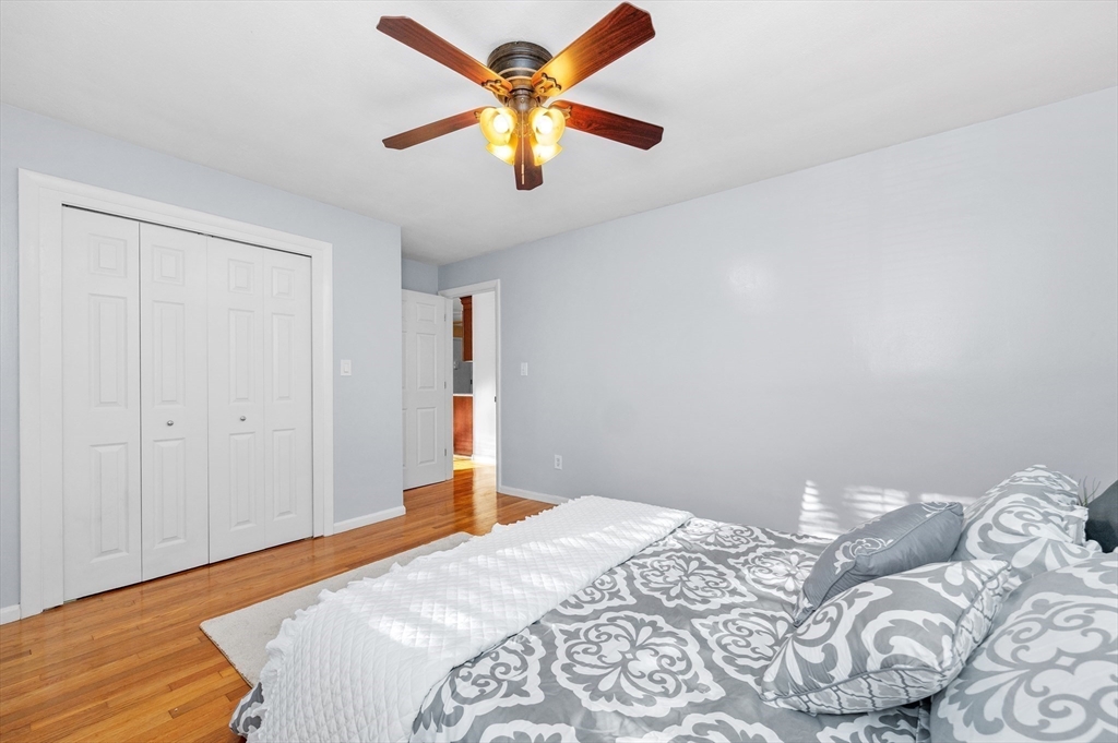 33 Jacqueline Road, Unit D Waltham, MA 02452 - Photo 16 of 26 a bedroom with a bed and a chandelier