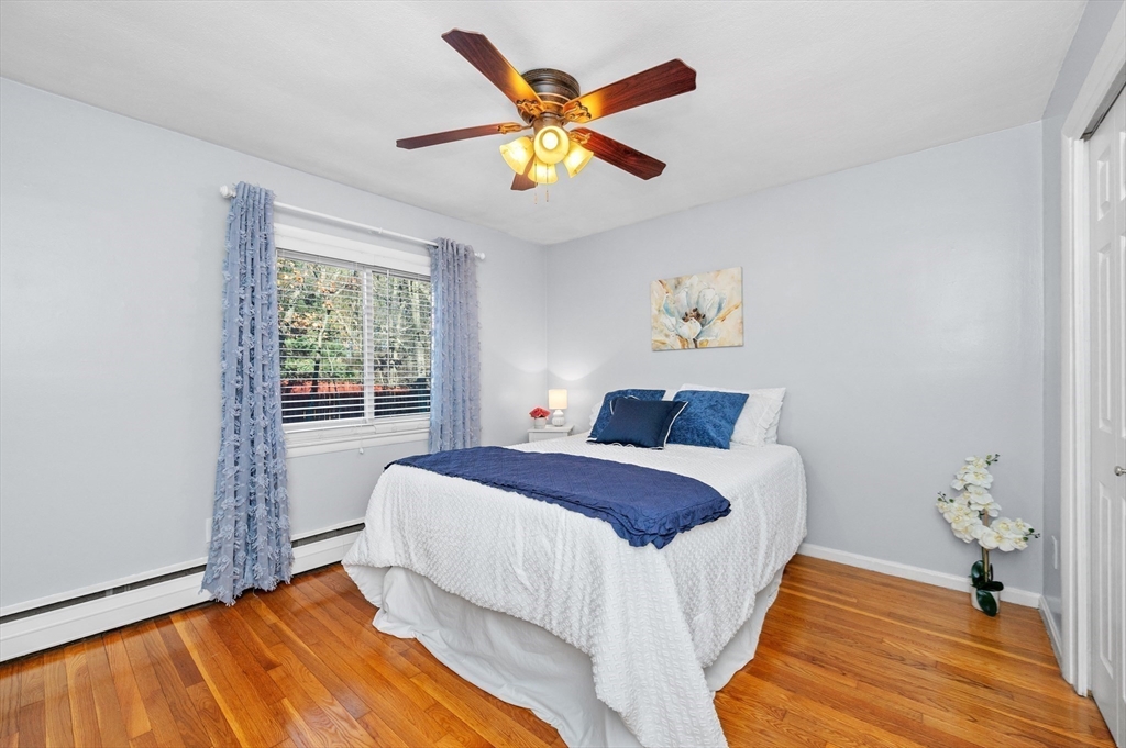 33 Jacqueline Road, Unit D Waltham, MA 02452 - Photo 17 of 26 a bedroom with a bed and a chandelier