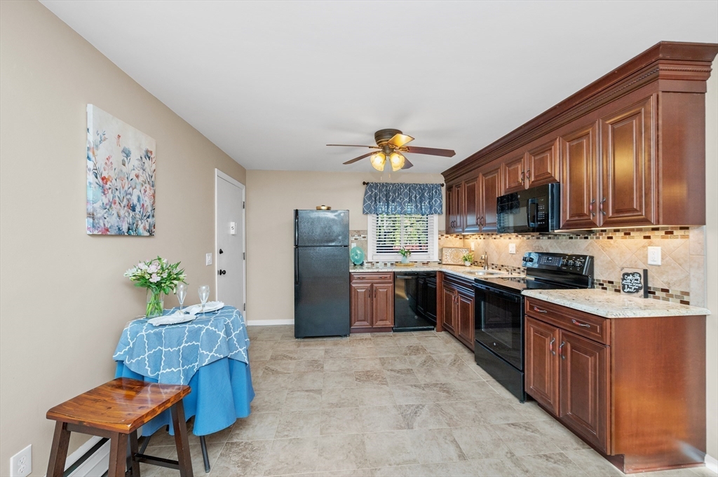 33 Jacqueline Road, Unit D Waltham, MA 02452 - Photo 3 of 26 a kitchen with stainless steel appliances granite countertop a refrigerator a stove a sink dishwasher and a dining table with wooden floor