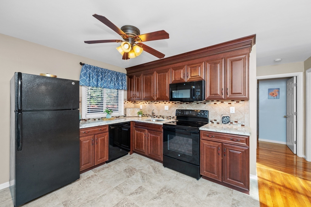 33 Jacqueline Road, Unit D Waltham, MA 02452 - Photo 6 of 26 a kitchen with stainless steel appliances granite countertop a refrigerator a stove top oven a sink and dishwasher