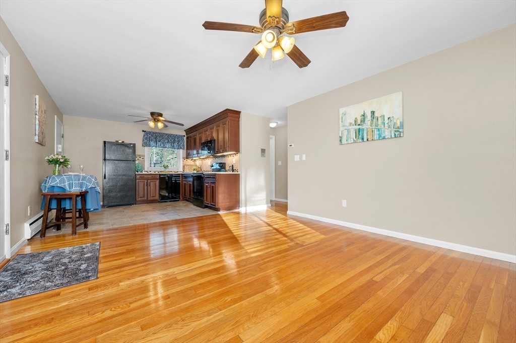33 Jacqueline Road, Unit D Waltham, MA 02452 - Photo 7 of 26 a room with kitchen island stainless steel appliances furniture a chandelier and a view of kitchen