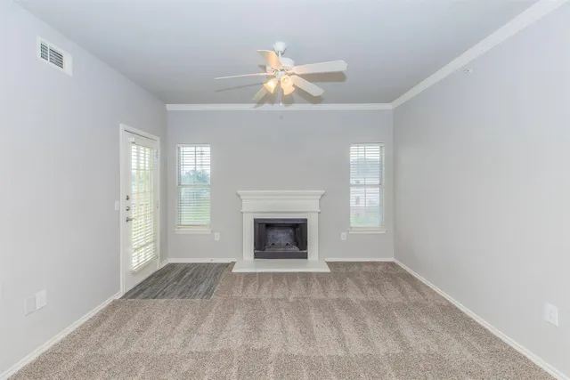 a view of an empty room with window and fire place