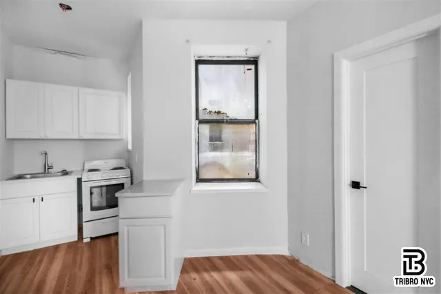 a kitchen with a refrigerator and white cabinets