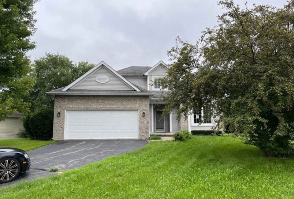 12848 Westbrook Pointe Winnebago, IL 61088 - Photo 2 of 3 a front view of a house with a yard and garage