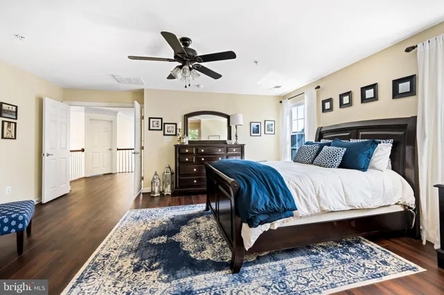 a bedroom with a large bed and wooden floor