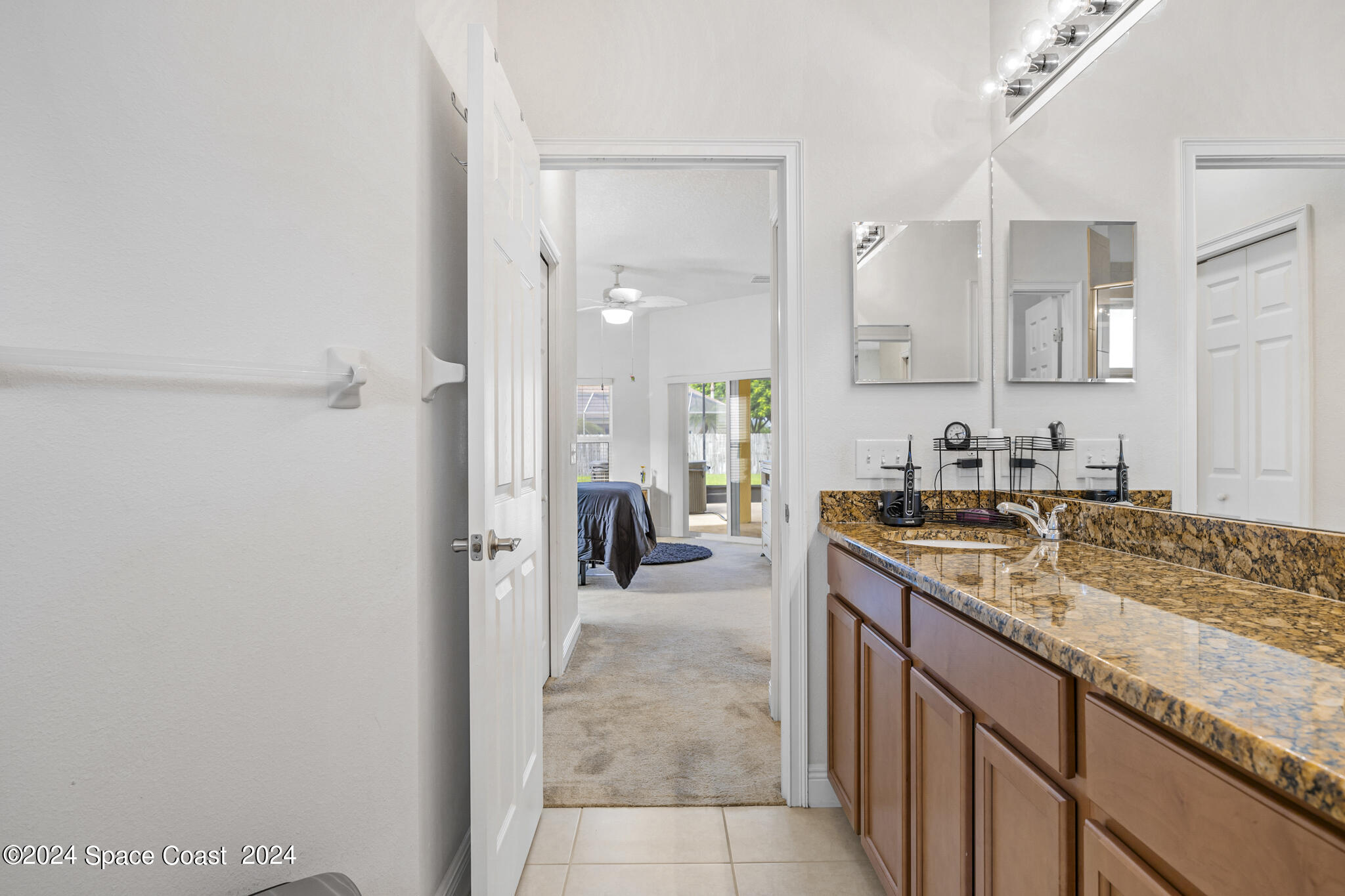 572 Glenbrook Circle Rockledge, FL 32955 - Photo 30 of 35 a en suite bathroom with a granite countertop sink and a mirror
