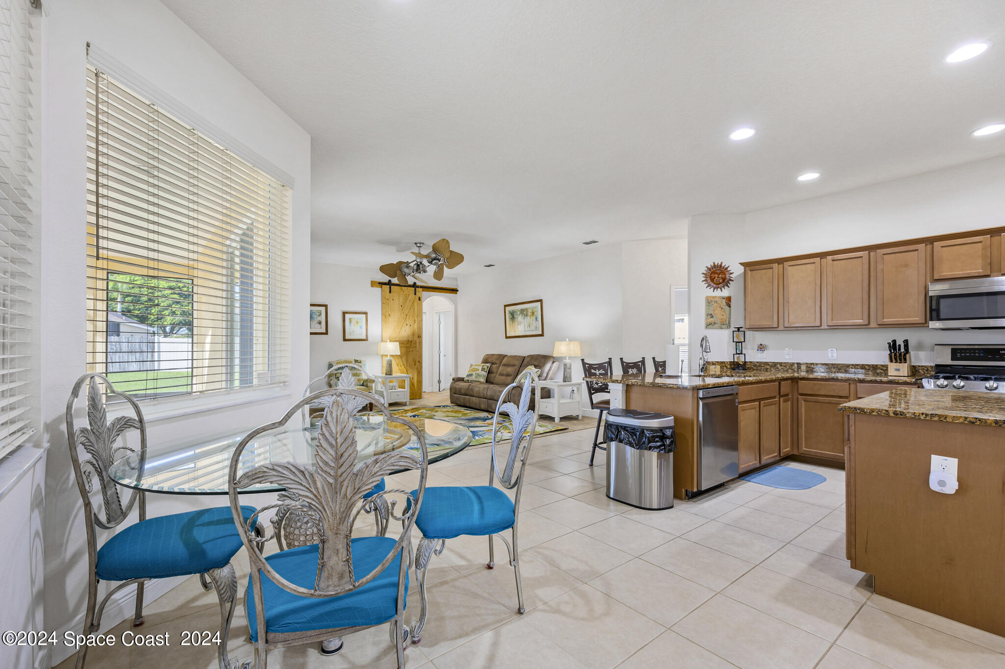 572 Glenbrook Circle Rockledge, FL 32955 - Photo 9 of 35 a living room with furniture a kitchen view and a large window
