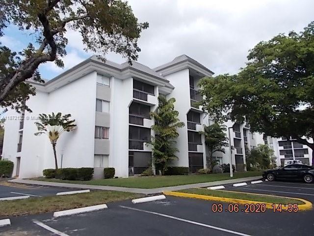 721 North Pine Island Road, Unit 201 Plantation, FL 33324 - Photo 18 of 18 a view of a white building among the street with palm trees