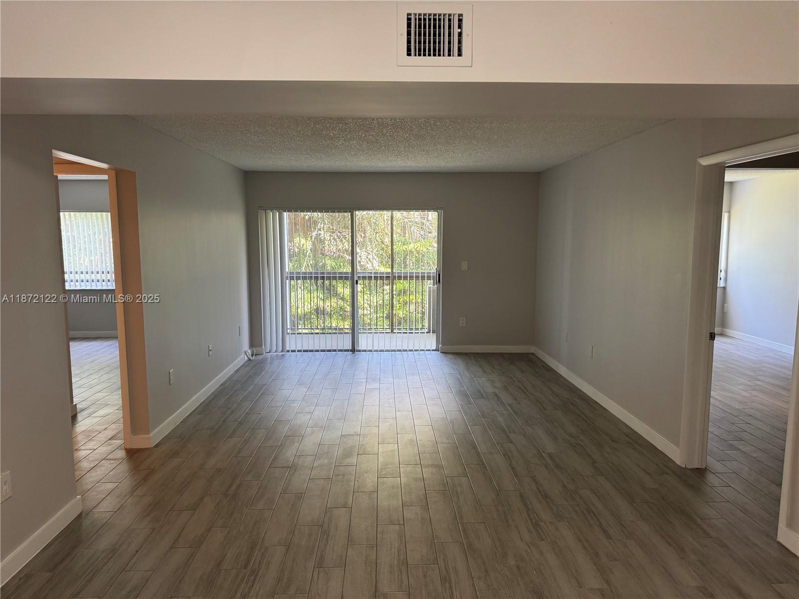 721 North Pine Island Road, Unit 201 Plantation, FL 33324 - Photo 2 of 18 an empty room with wooden floor and windows