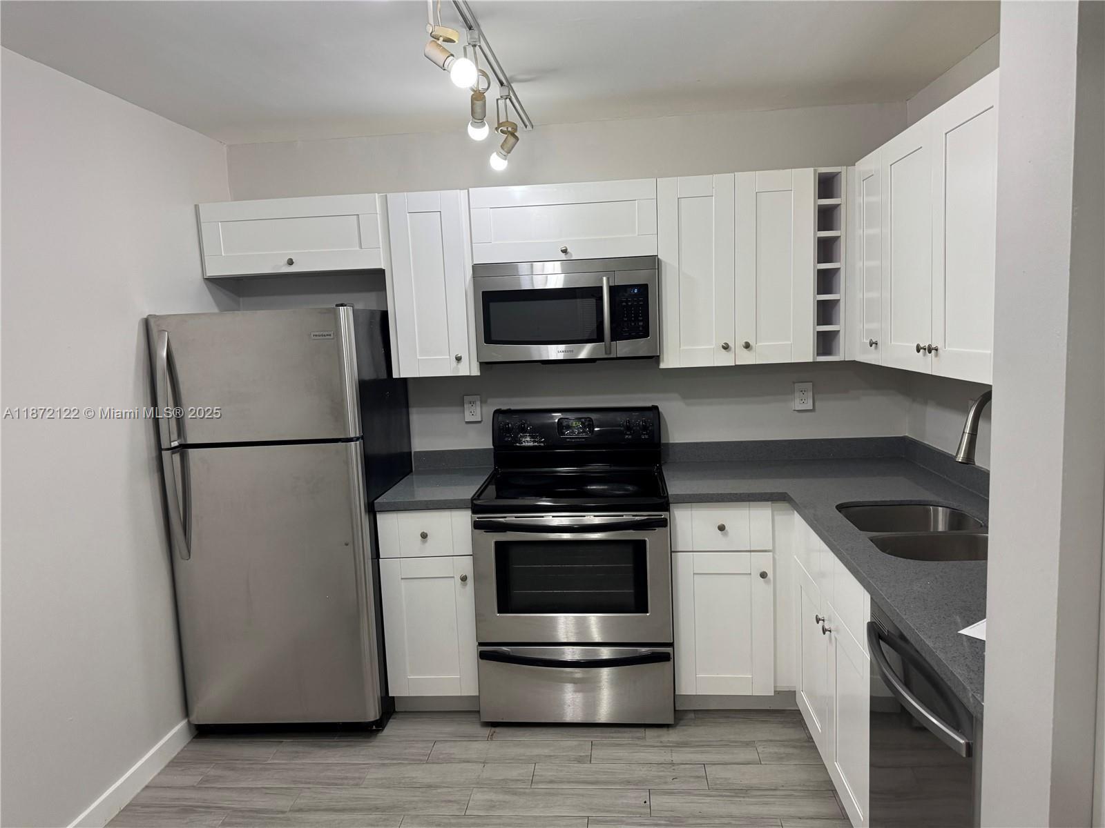 721 North Pine Island Road, Unit 201 Plantation, FL 33324 - Photo 5 of 18 a kitchen with a stove and a refrigerator