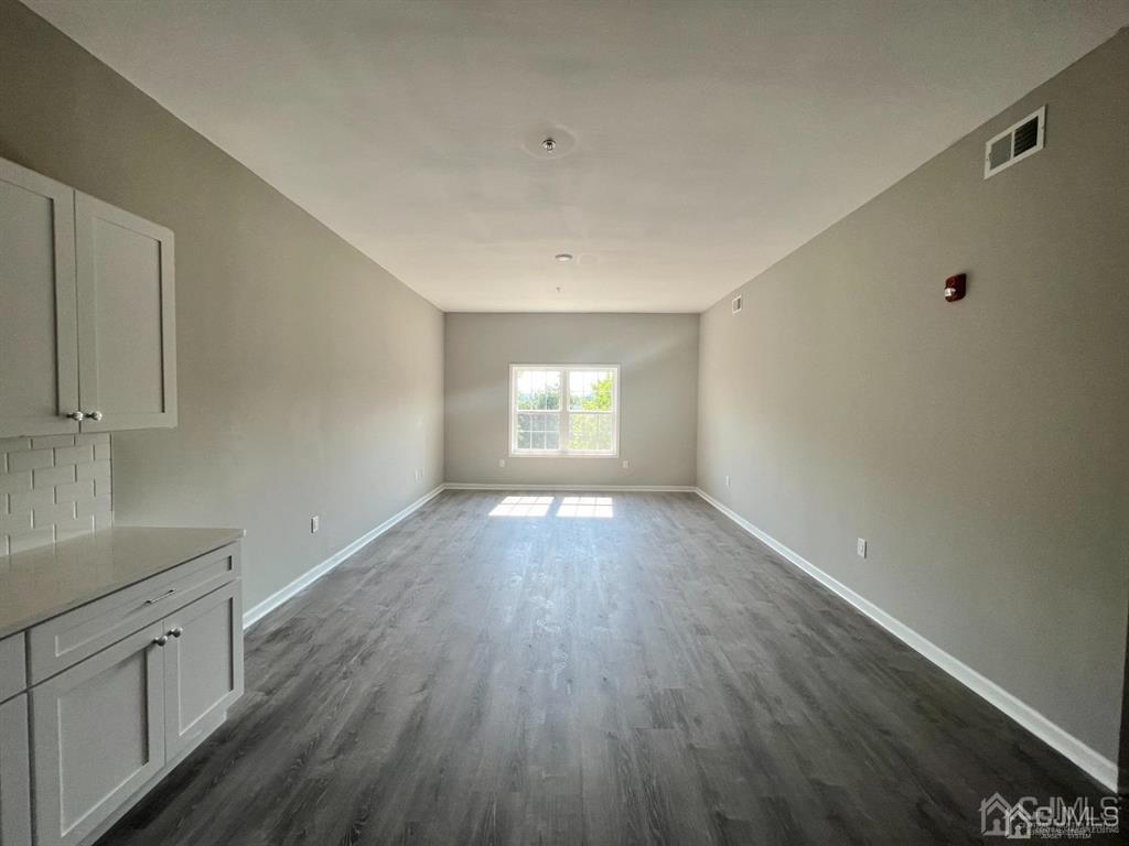 37 Old Trenton Road, Unit 17 Cranbury, NJ 08512 - Photo 3 of 11 an empty room with wooden floor and windows