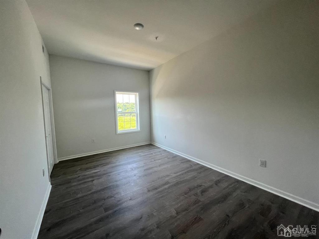 37 Old Trenton Road, Unit 17 Cranbury, NJ 08512 - Photo 6 of 11 an empty room with wooden floor and windows