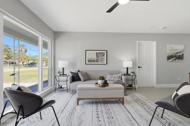 a living room with furniture and a floor to ceiling window
