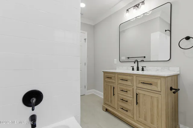a bathroom with a granite countertop sink a mirror and shower