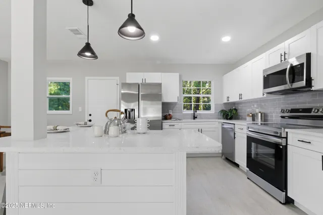 a kitchen with stainless steel appliances granite countertop a sink and stove top oven