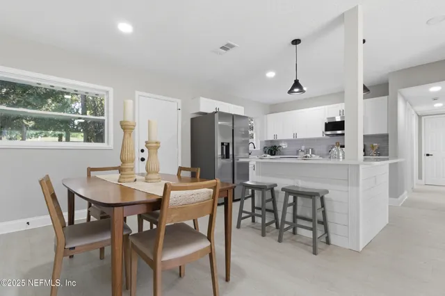 a kitchen with kitchen island a dining table and chairs