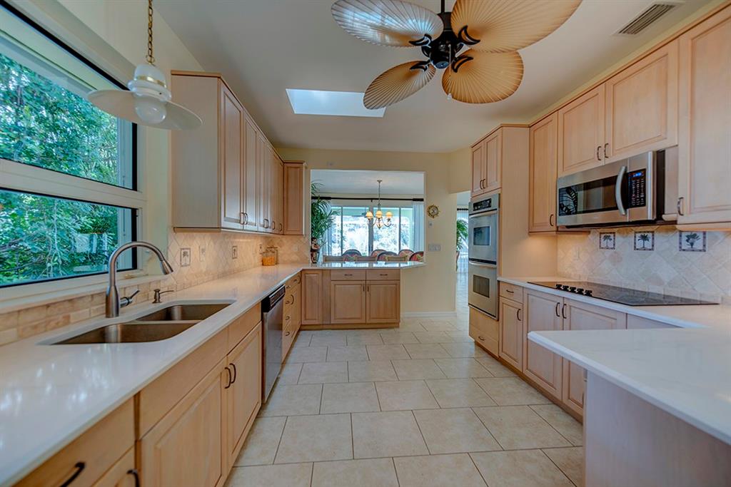 107 South Sewalls Point Road Stuart, FL 34996 - Photo 25 of 57 a kitchen with stainless steel appliances granite countertop a sink and dishwasher a stove top oven with wooden floor