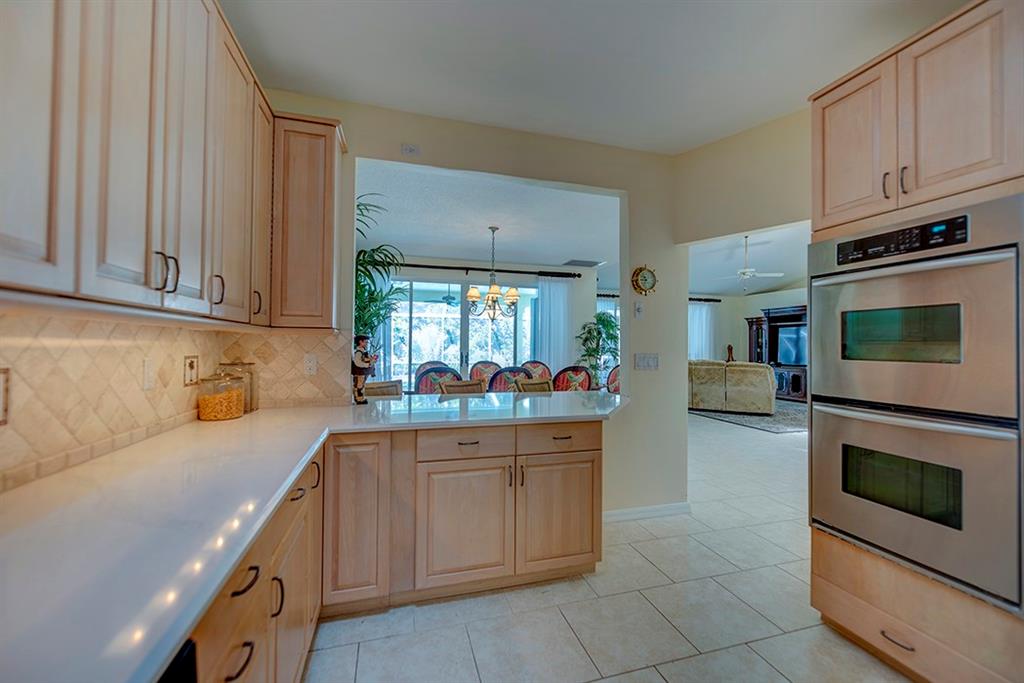 107 South Sewalls Point Road Stuart, FL 34996 - Photo 26 of 57 a kitchen with kitchen island granite countertop a stove top oven microwave and cabinets