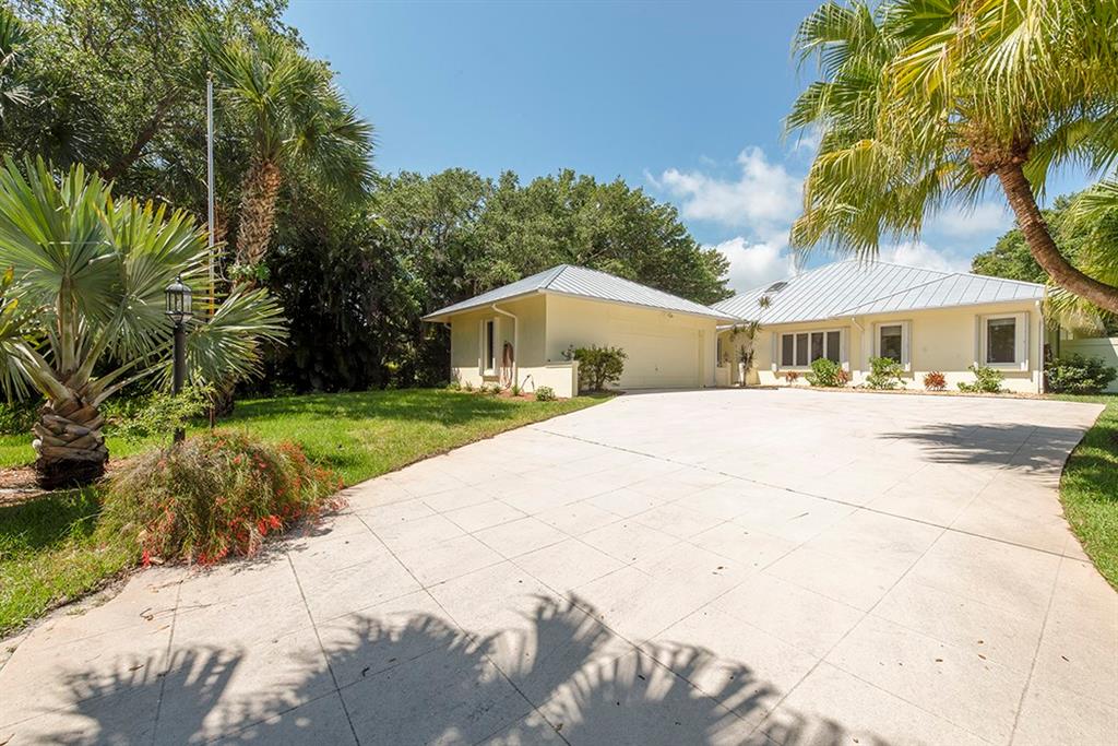 107 South Sewalls Point Road Stuart, FL 34996 - Photo 3 of 57 a house with palm tree in front of it