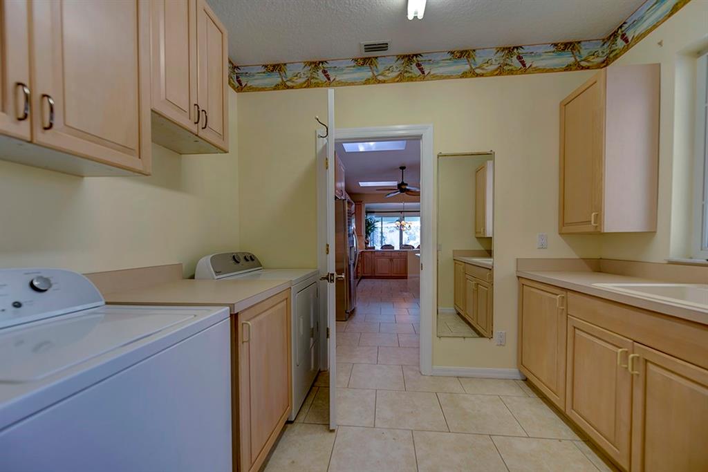 107 South Sewalls Point Road Stuart, FL 34996 - Photo 31 of 57 a utility room with cabinets washer and dryer