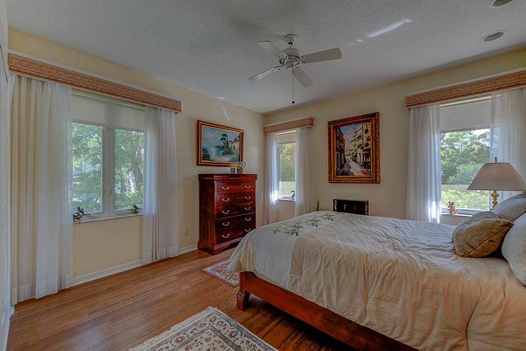 107 South Sewalls Point Road Stuart, FL 34996 - Photo 40 of 57 a bedroom with a bed and wooden floor