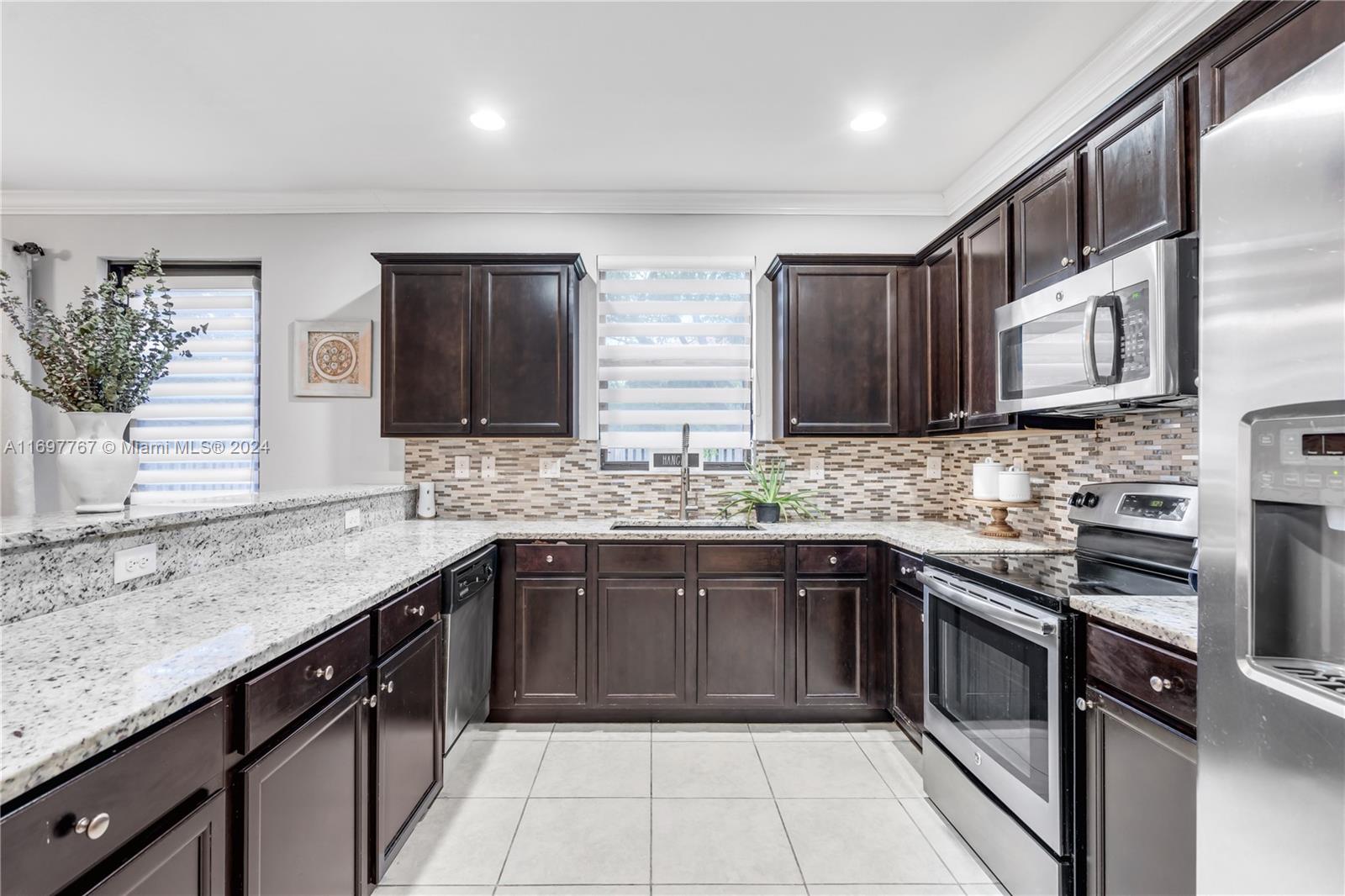 17403 Southwest 155th Court Miami, FL 33187 - Photo 1 of 42 a kitchen with stainless steel appliances granite countertop a sink stove and cabinets