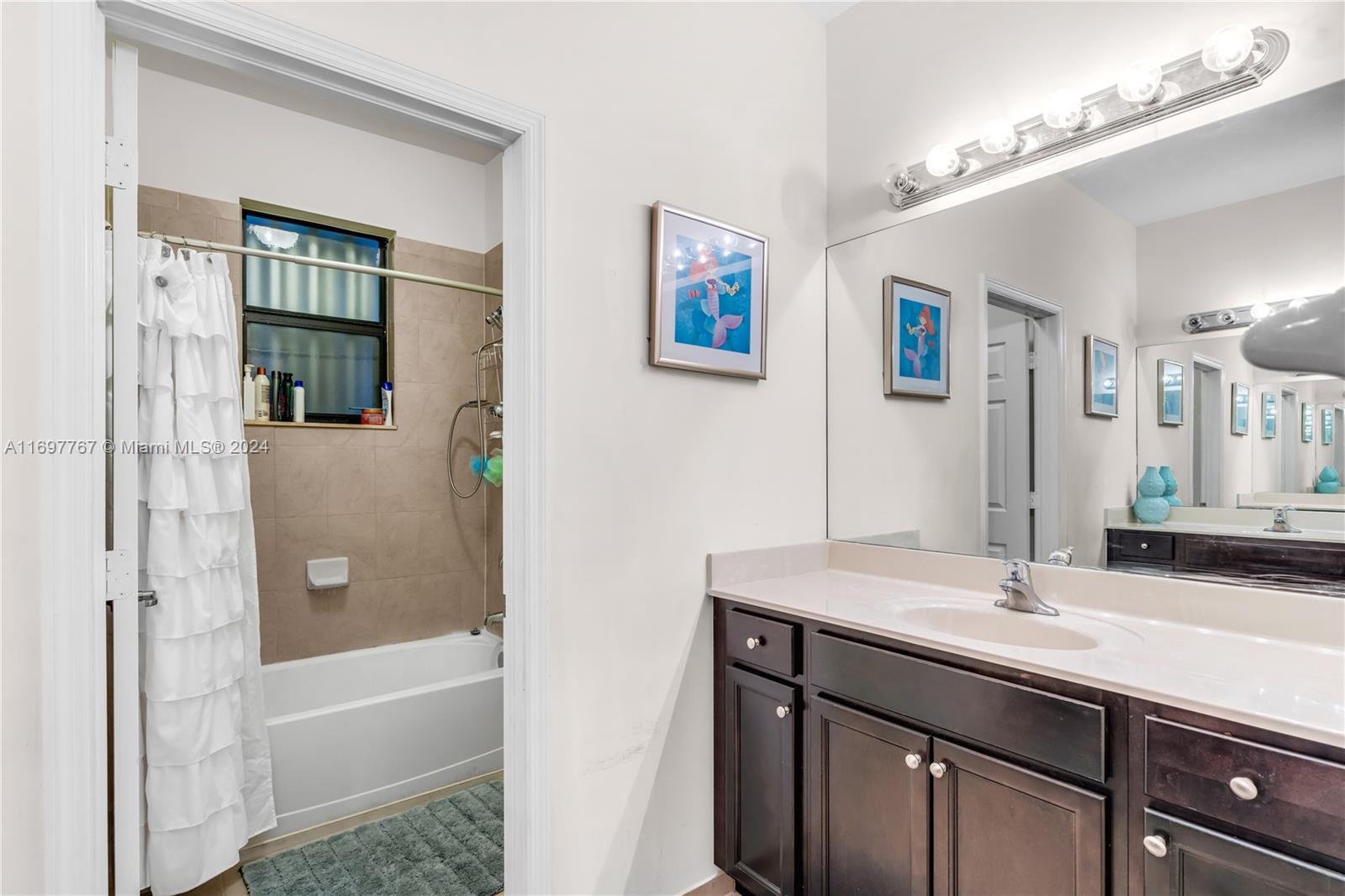 17403 Southwest 155th Court Miami, FL 33187 - Photo 24 of 42 a bathroom with a sink tub shower and a mirror