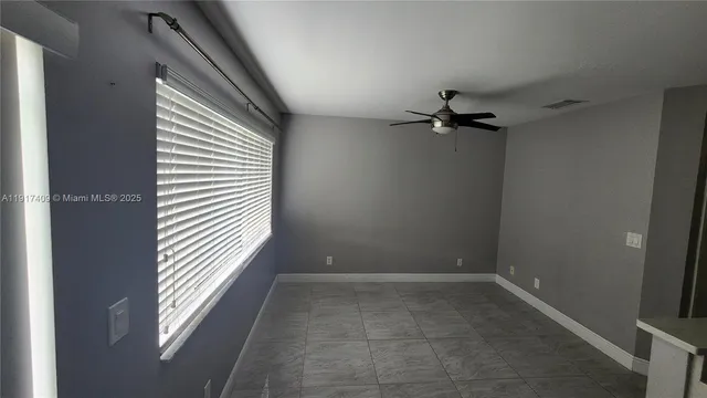 a view of a livingroom with a ceiling fan and window