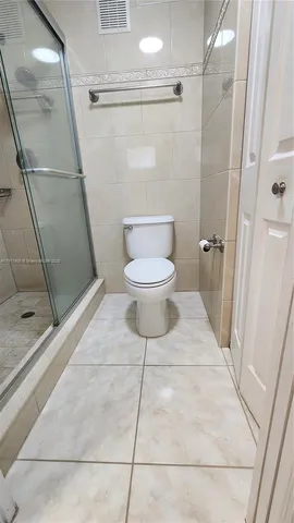 a bathroom with a toilet and a shower