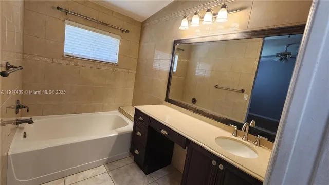 a bathroom with a tub sink and mirror