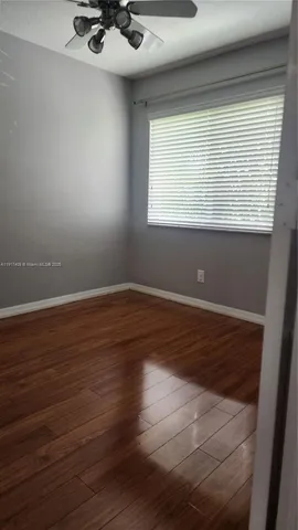 a view of a room with wooden floor and a window
