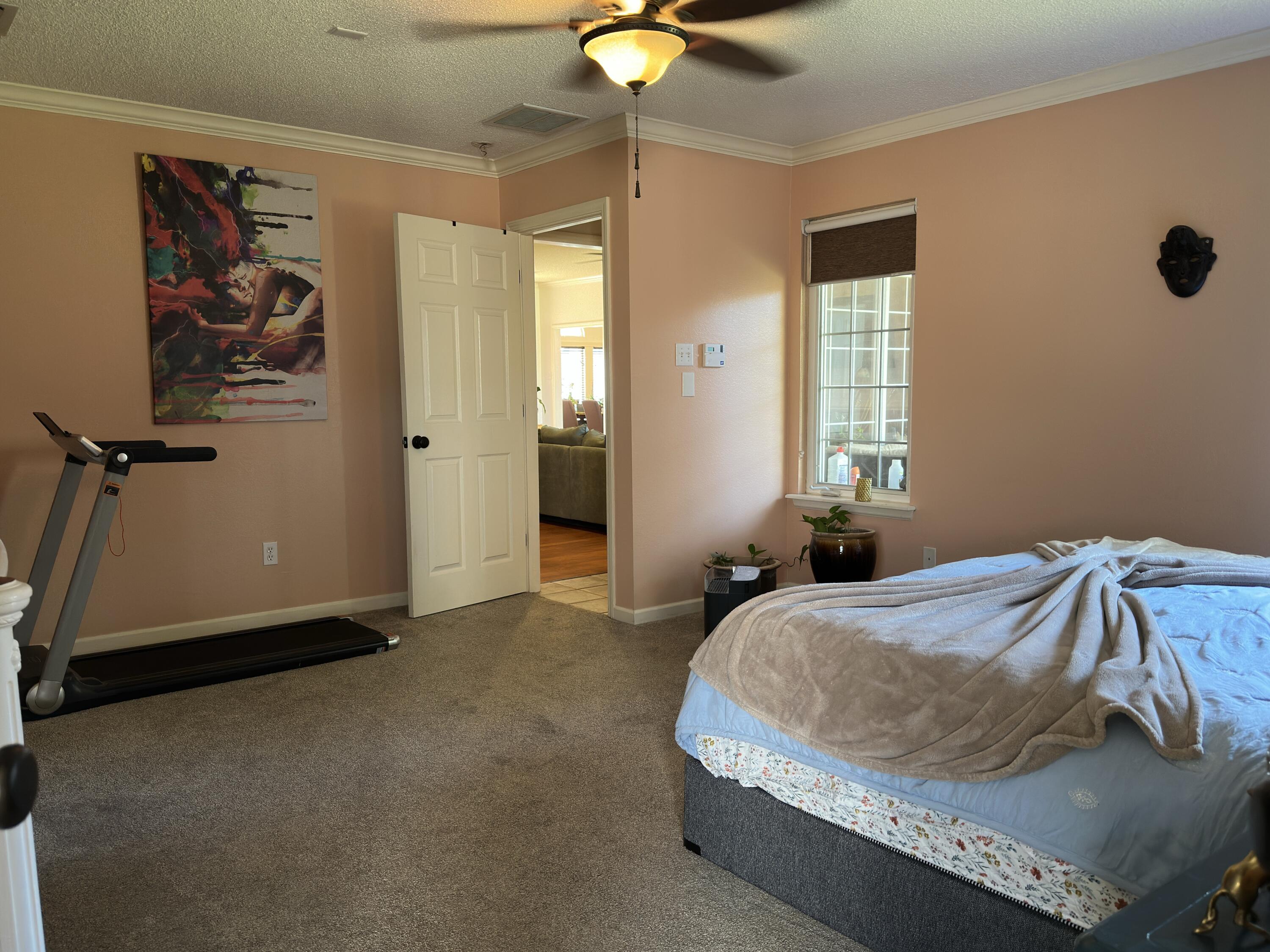 4902 103rd Street Lubbock, TX 79424 - Photo 18 of 23 a bedroom with a bed and a chandelier