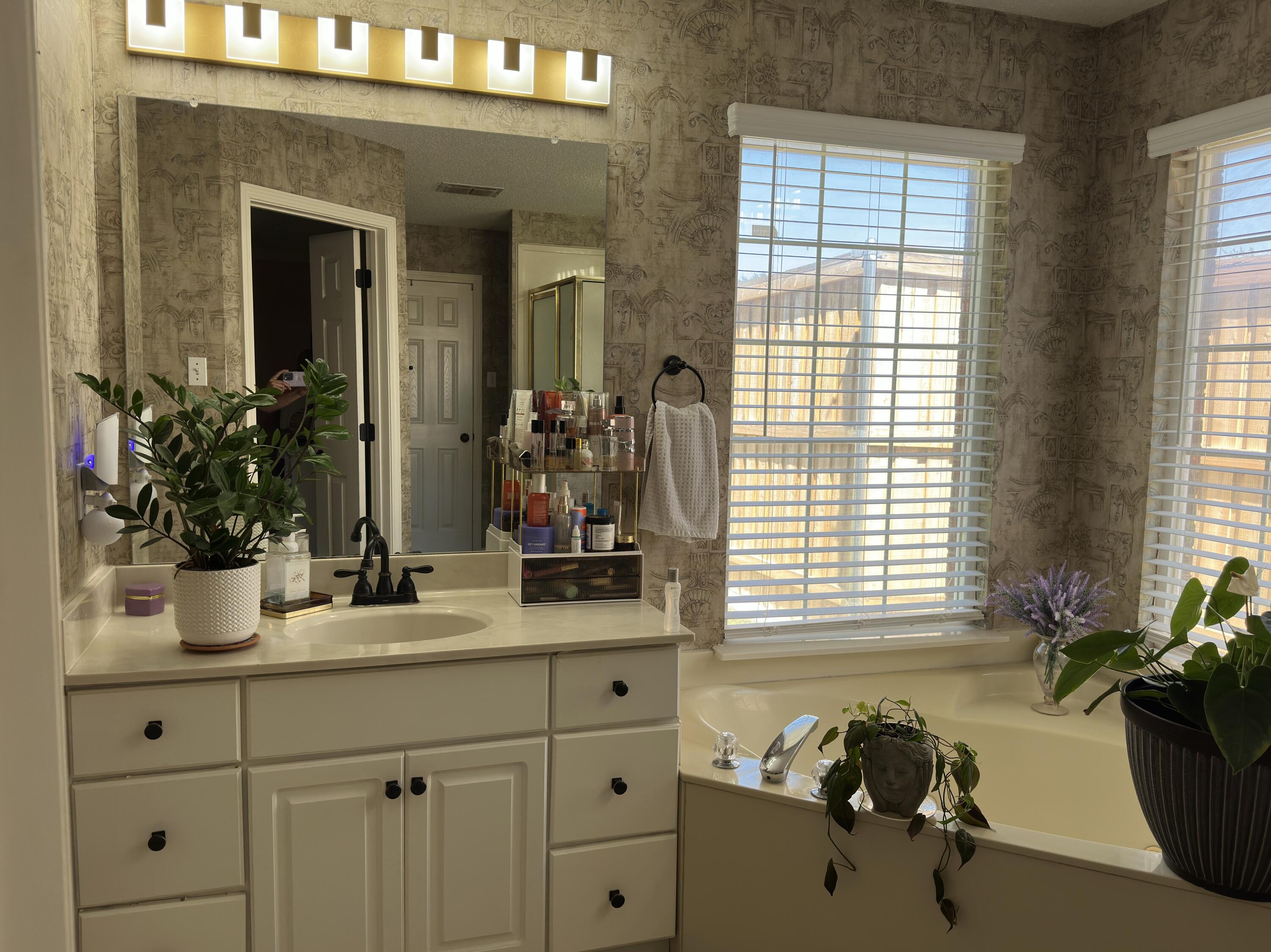 4902 103rd Street Lubbock, TX 79424 - Photo 20 of 23 a bathroom with a tub sink and mirror