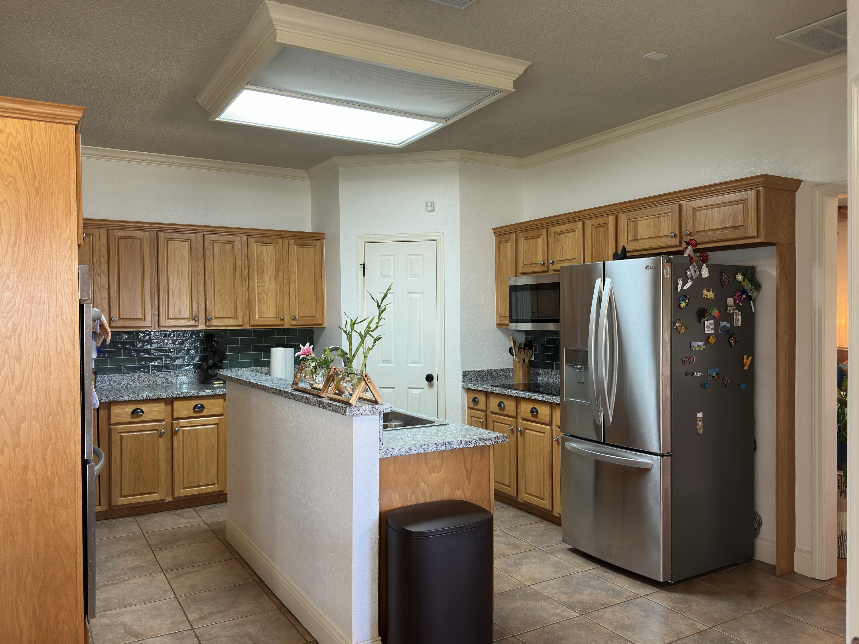 4902 103rd Street Lubbock, TX 79424 - Photo 5 of 23 a kitchen with stainless steel appliances granite countertop a refrigerator and a sink