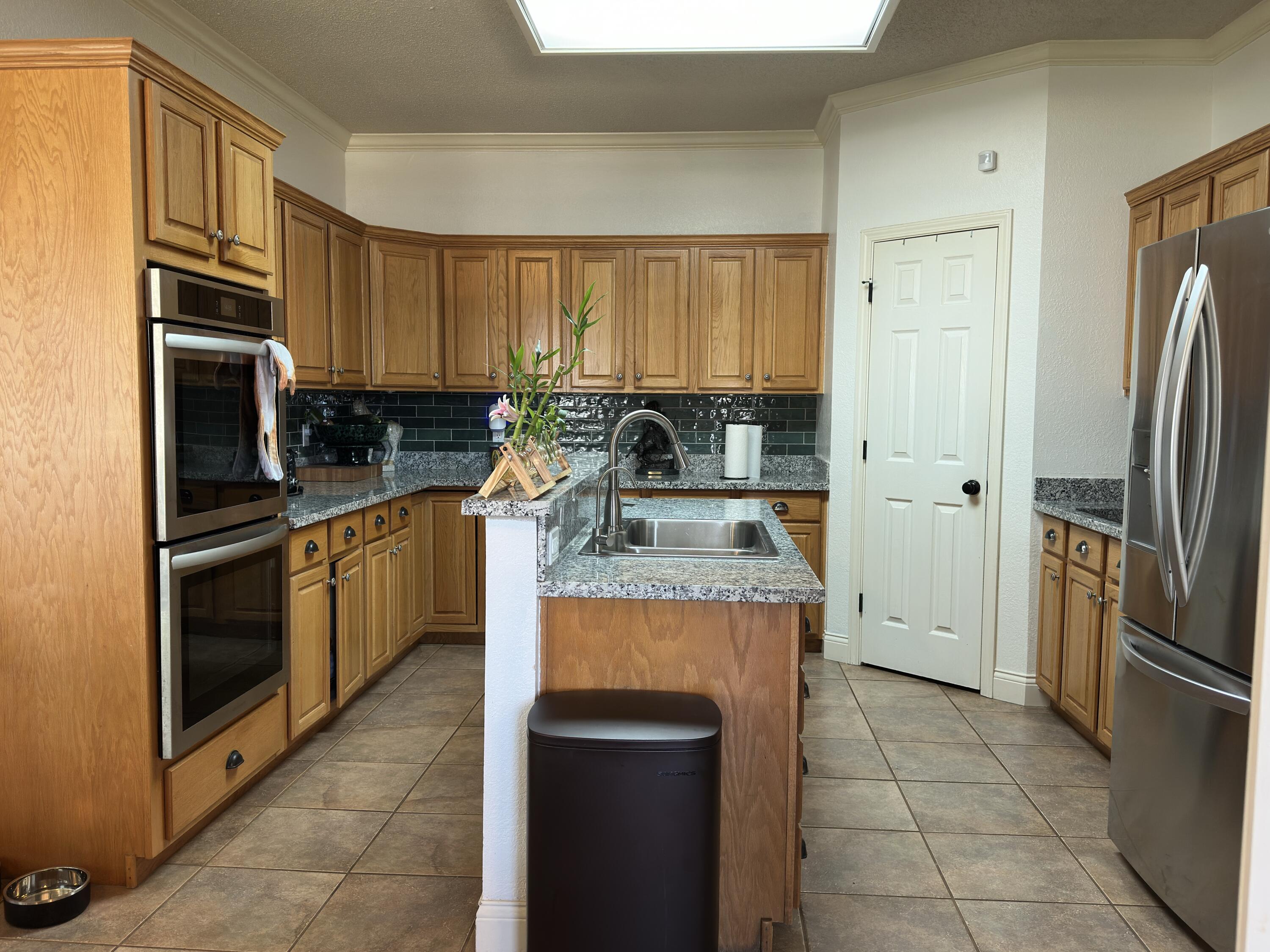 4902 103rd Street Lubbock, TX 79424 - Photo 6 of 23 a kitchen with a stove a refrigerator and a sink
