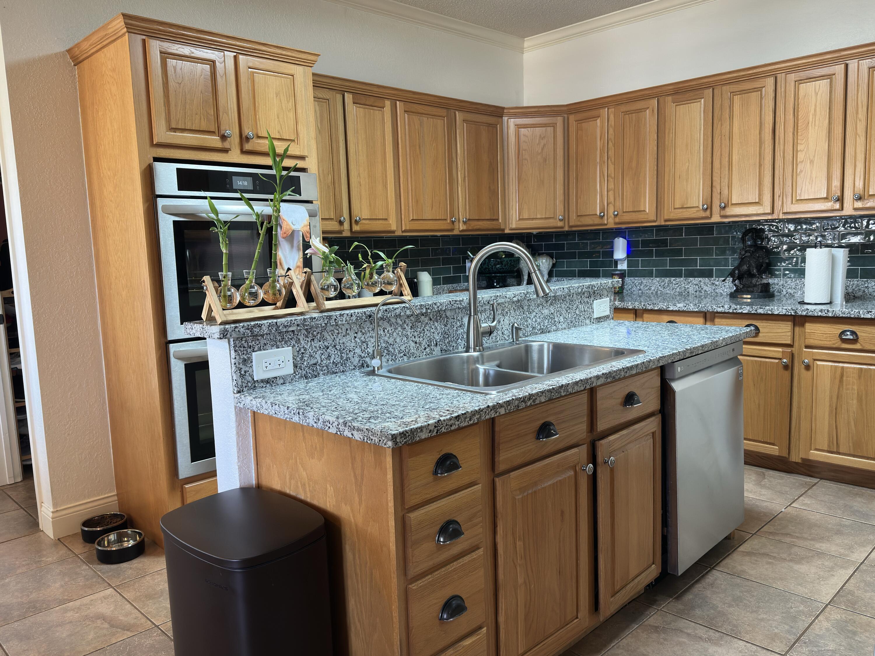 4902 103rd Street Lubbock, TX 79424 - Photo 7 of 23 a kitchen with stainless steel appliances granite countertop a sink stove and cabinets