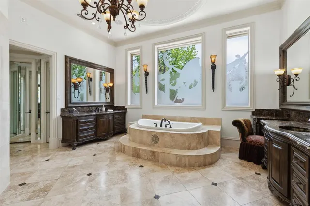 a spacious bathroom with a tub double sink and a mirror