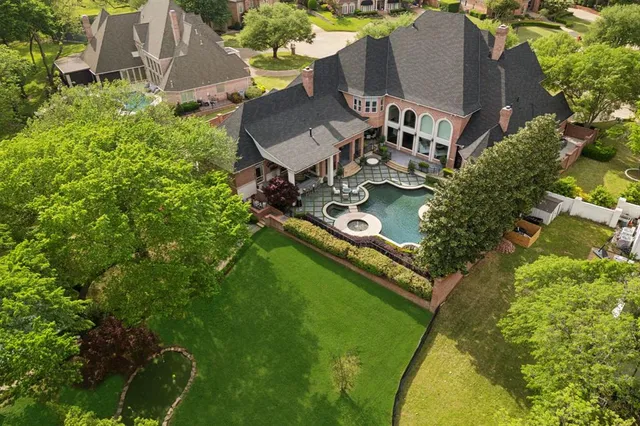 an aerial view of residential house with outdoor space and trees all around