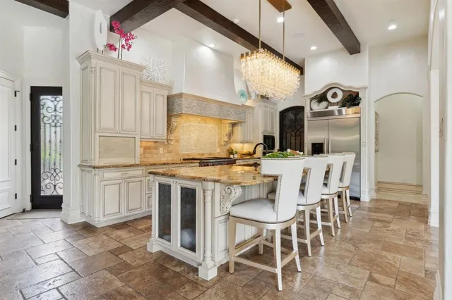a kitchen with stainless steel appliances kitchen island granite countertop a table and chairs in it