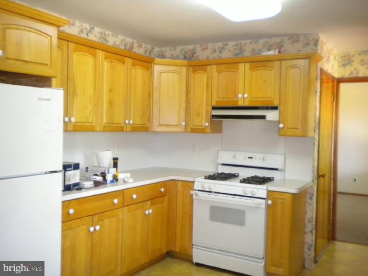 32 Cold Spring Road Mercerville, NJ 08619 - Photo 6 of 16 a kitchen with stainless steel appliances a stove a sink and a refrigerator with cabinets