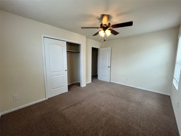 a view of an empty room and a ceiling fan