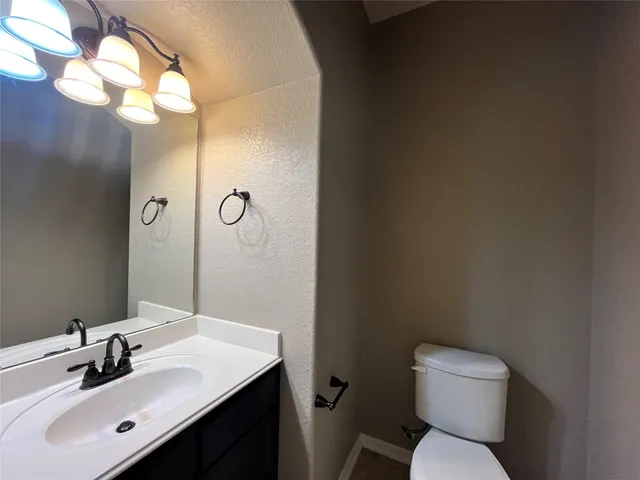 a bathroom with a sink mirror vanity and toilet