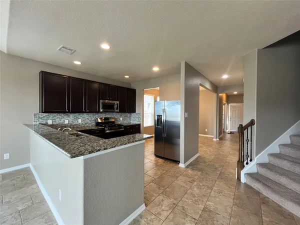 a kitchen with stainless steel appliances granite countertop a sink stove and refrigerator