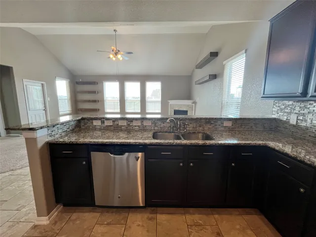 a kitchen with granite countertop a sink stainless steel appliances and cabinets