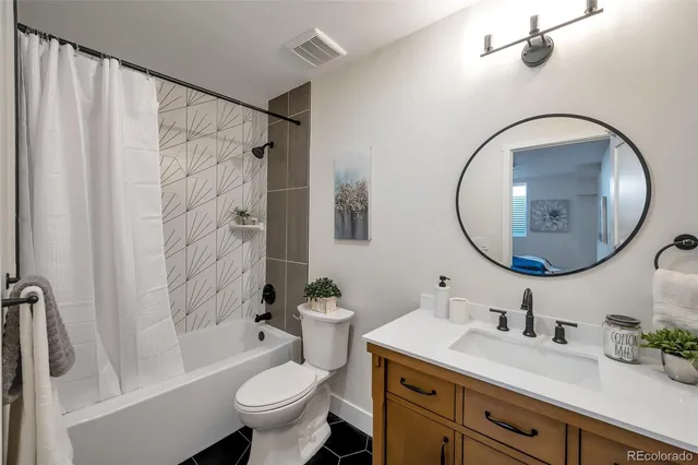 a bathroom with a granite countertop sink mirror vanity and toilet