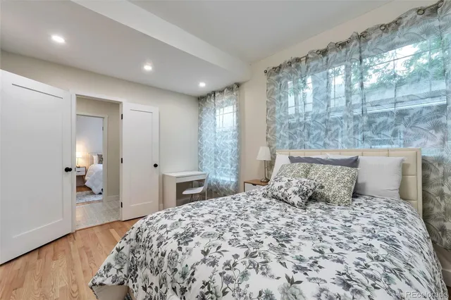 a bedroom with a large bed and wooden floor