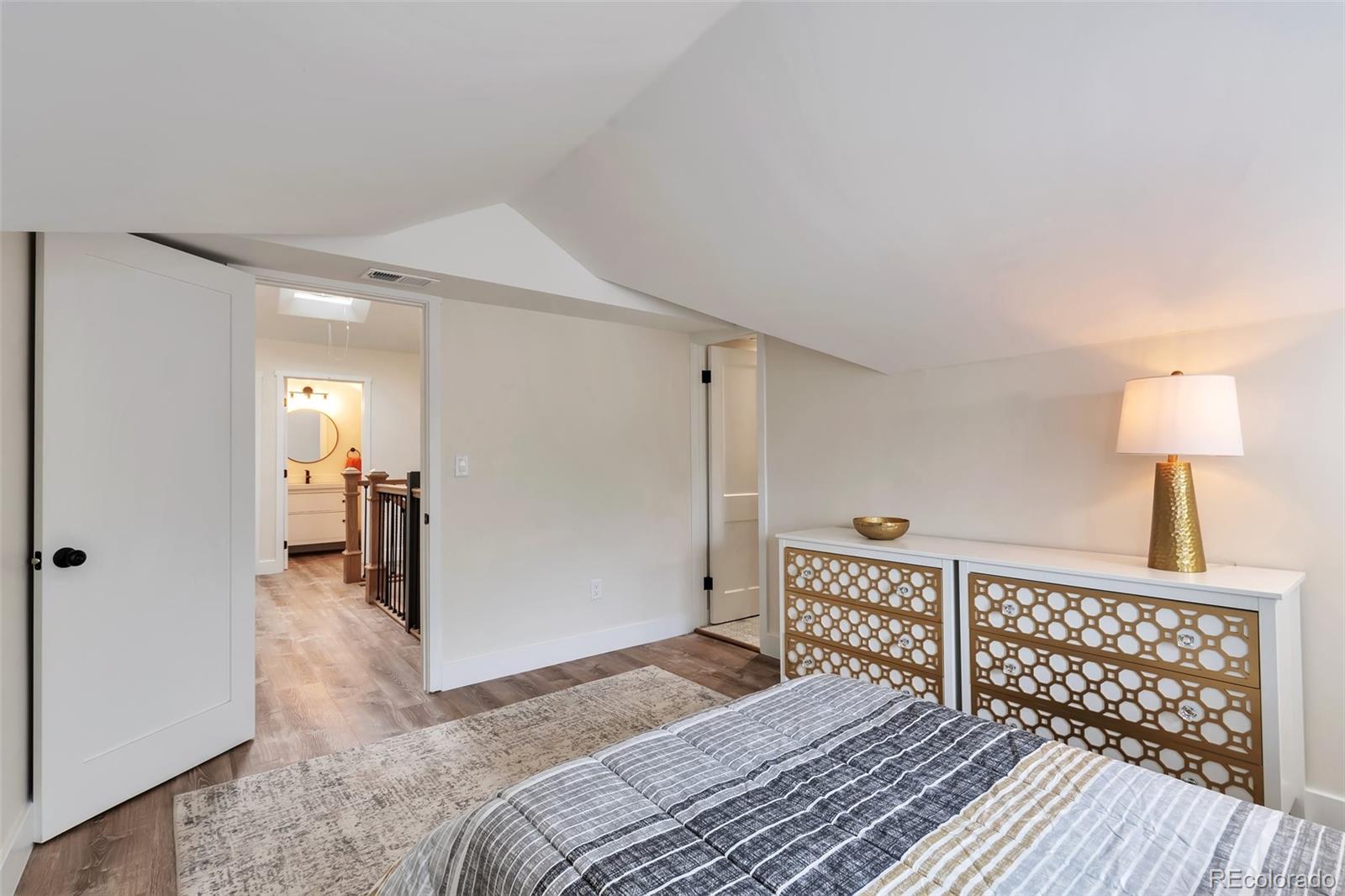 1417 Monroe Street Denver, CO 80206 - Photo 21 of 31 a bedroom with a bed and wooden floor