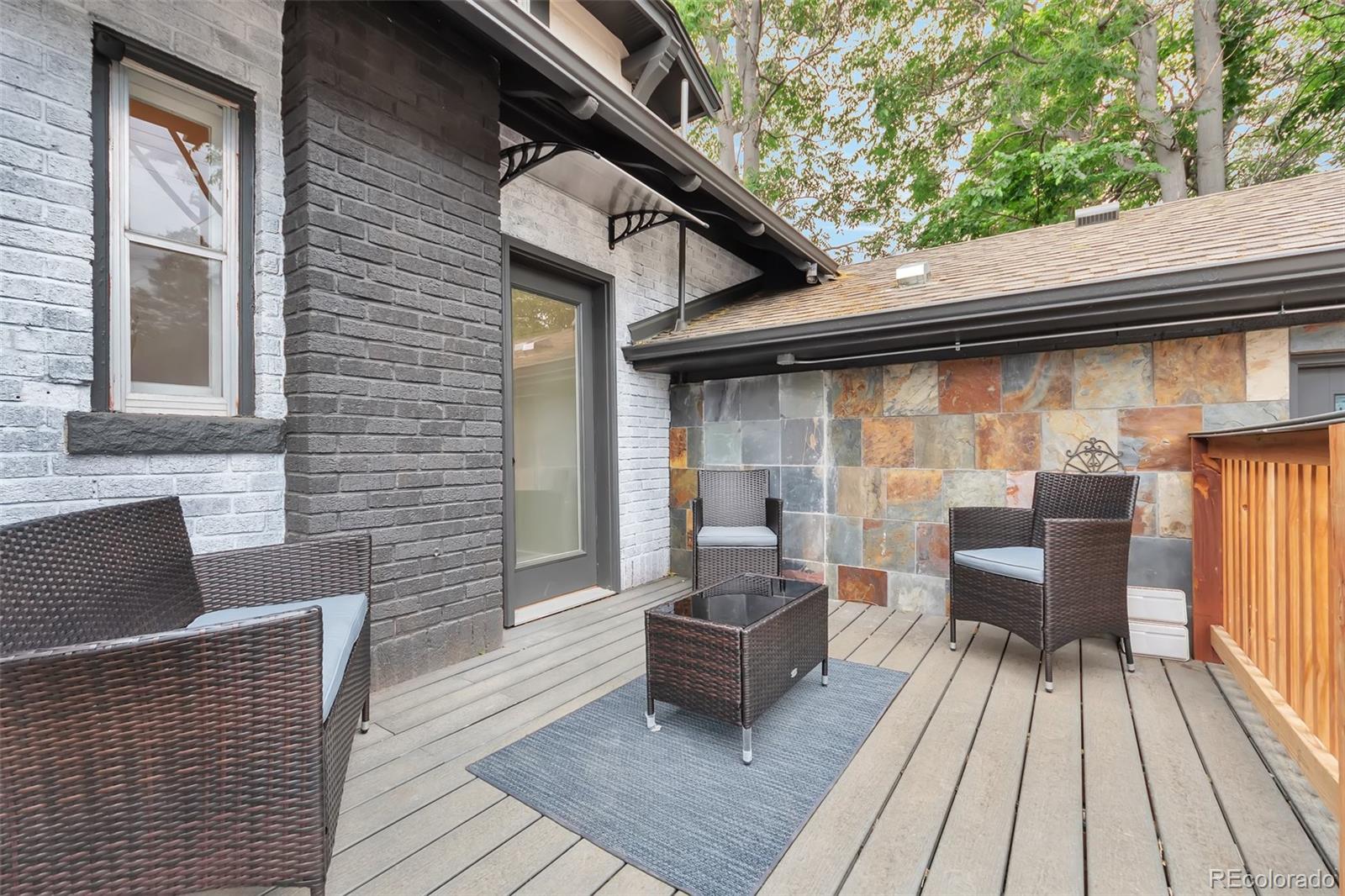 1417 Monroe Street Denver, CO 80206 - Photo 23 of 31 a brick house with table and chairs
