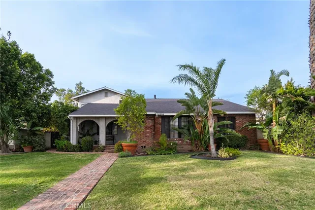 a front view of a house with a garden