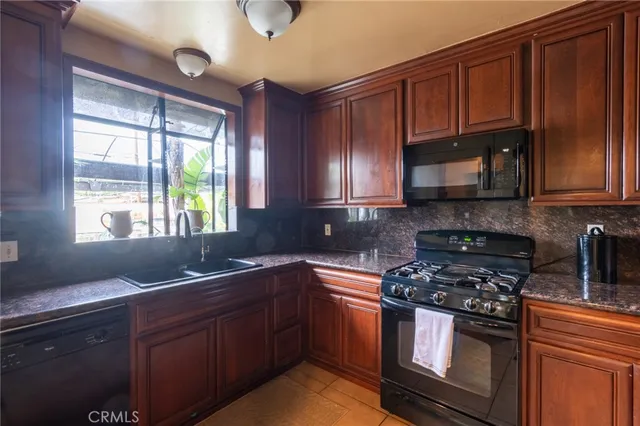 a kitchen with stainless steel appliances granite countertop wooden cabinets and a stove top oven